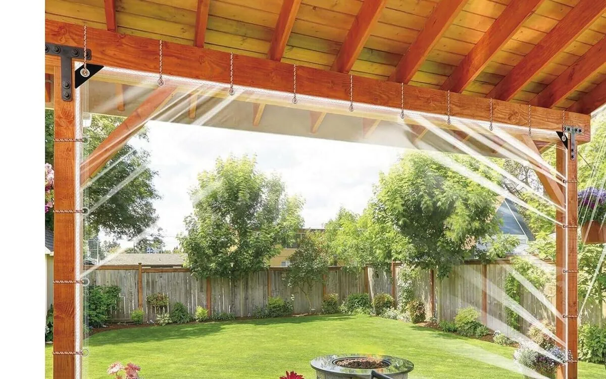 A clear PVC tarpaulin fitted as a waterproof cover over an outdoor patio space
